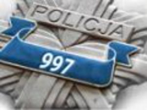 Na zdjęciu widoczna odznaka policyjna w kolorze srebrnym z napisem Policja i numerem 997 na niebieskim tle.
