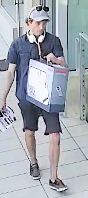 Na zdjęciu widoczny mężczyzna ubrany w koszulkę z krótkim rękawem koloru niebieskiego, krótkie spodenki koloru ciemno-zielonego. Na głowie ma czapkę z daszkiem koloru szarego.