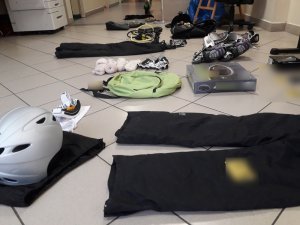 Na zdjęciu widoczny leżący sprzęt w postaci spodni do nurkowania, kasku, rękawic odzyskany przez policjantów.
