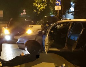Na zdjęciu widoczny zatrzymany mężczyzna ubrany na ciemno, leżący na ulicy z założonymi kajdankami na ręce.