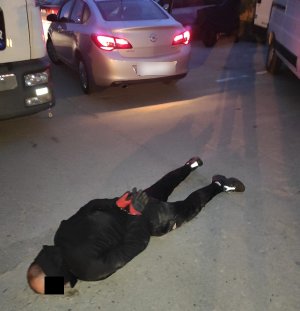 Na zdjęciu widoczny zatrzymany mężczyzna, który ma założone kajdanki i leży na ziemi.