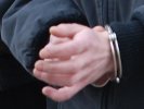 Na zdjęciu widoczne dłonie zatrzymanego, na których ma nałożone kajdanki.