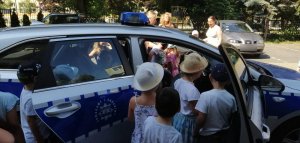 Na zdjęciu widoczny radiowóz policyjny i dzieci.