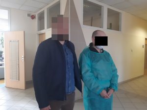 Na zdjęciu widoczny nieumundurowany policjant, który stoi przy zatrzymanym mężczyźnie.