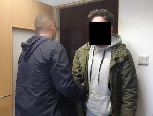 Na zdjęciu widoczny nieumundurowany policjant i zatrzymany mężczyzna.