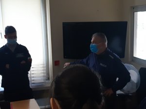 Na zdjęciu widoczny umundurowany policjant wraz uczniami klasy policyjnej.