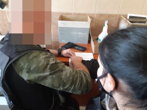Na zdjęciu widoczny nieumundurowany policjant wraz uczniami klasy policyjnej.