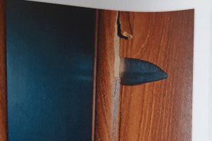 Na zdjęciu widoczny nóż wbity w drzwi.