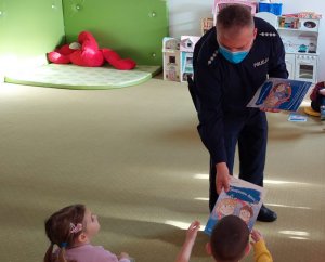 Na zdjęciu widoczny umundurowany policjant i dzieci.