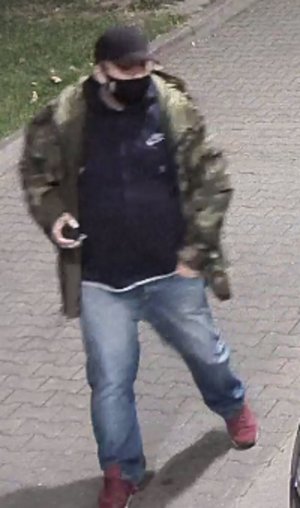 Na zdjęciu widoczny mężczyzna, ma czapkę z daszkiem na głowie koloru ciemnego, zielona kurtkę, granatową bluzę i spodnie typu jeans.