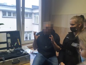 Na zdjęciu widoczny nieumundurowany policjant i uczniowie klasy policyjnej.