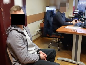 Na zdjęciu widoczny nieumundurowany policjant i zatrzymany mężczyzna