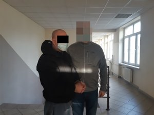 Na zdjęciu widoczny nieumundurowany policjant i zatrzymany mężczyzna.