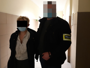 Na zdjęciu widoczny nieumundurowany policjant i zatrzymana kobieta.