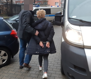 Na zdjęciu widoczny nieumundurowany policjant i zatrzymana kobieta.