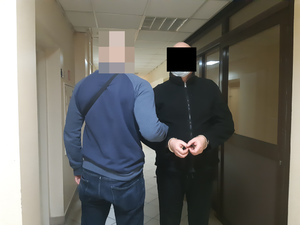 Na zdjęciu widoczny nieumundurowany policjant i zatrzymany mężczyzna.