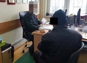 Na zdjęciu widoczny nieumundurowany policjant i zatrzymany mężczyzna.