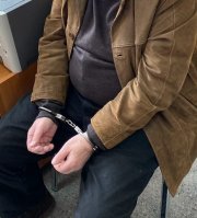 Na zdjęciu widoczny zatrzymany mężczyzna, który ma założone kajdanki na ręce.