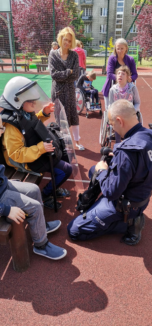 Na zdjęciu widać umundurowanego policjanta i dzieci.