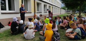 Na zdjęciu widoczny umundurowany policjant i dzieci.