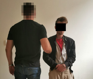 Na zdjęciu widoczny nieumundurowany policjant i zatrzymany mężczyzna.