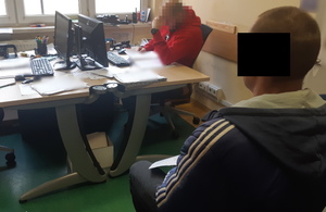 Na zdjęciu widoczny policjant i zatrzymany mężczyzna.