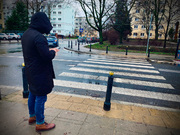 Na zdjęciu widać mężczyznę stojącego przed przejściem dla pieszych.