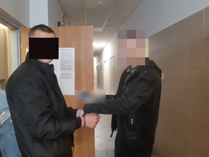 Na zdjęciu widać nieumundurowanego policjanta i zatrzymanego mężczyznę.