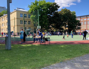 Plac szkolny i osoby na boisku.