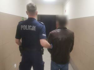 Umundurowany policjant i zatrzymany mężczyzna.