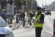 Policjant umundurowany stoi na ulicy.