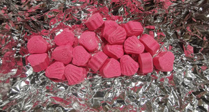 Foliowe opakowanie a na nim różowe tabletki.