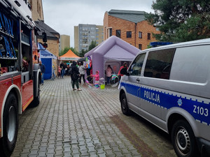 Radiowóz policyjny, straż pożarna i ludzie na pikniku.