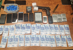 Banknoty o nominale 50 zł, broń, nabój, legitymacja policyjna, telefony komórkowe, zawiniątka niebieskie narkotyków.