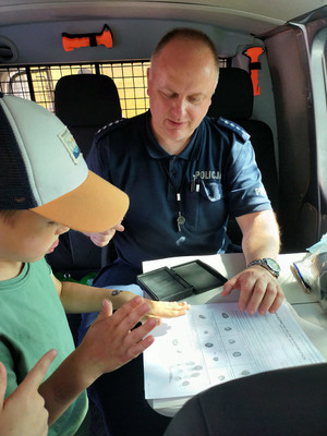 Policjant robi daktyloskopię.