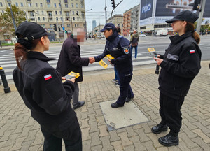 Policjantka i klasa policyjna rozadje ulotki.