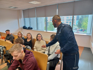 Policjant rozdaje ulotki.