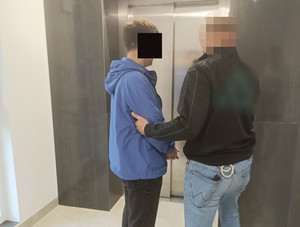 Policjant stoi z zatrzymanym.