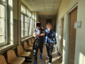Policjantka prowadzi zatrzymanego.