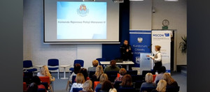 Policjant i inne osoby podczas konferencji.